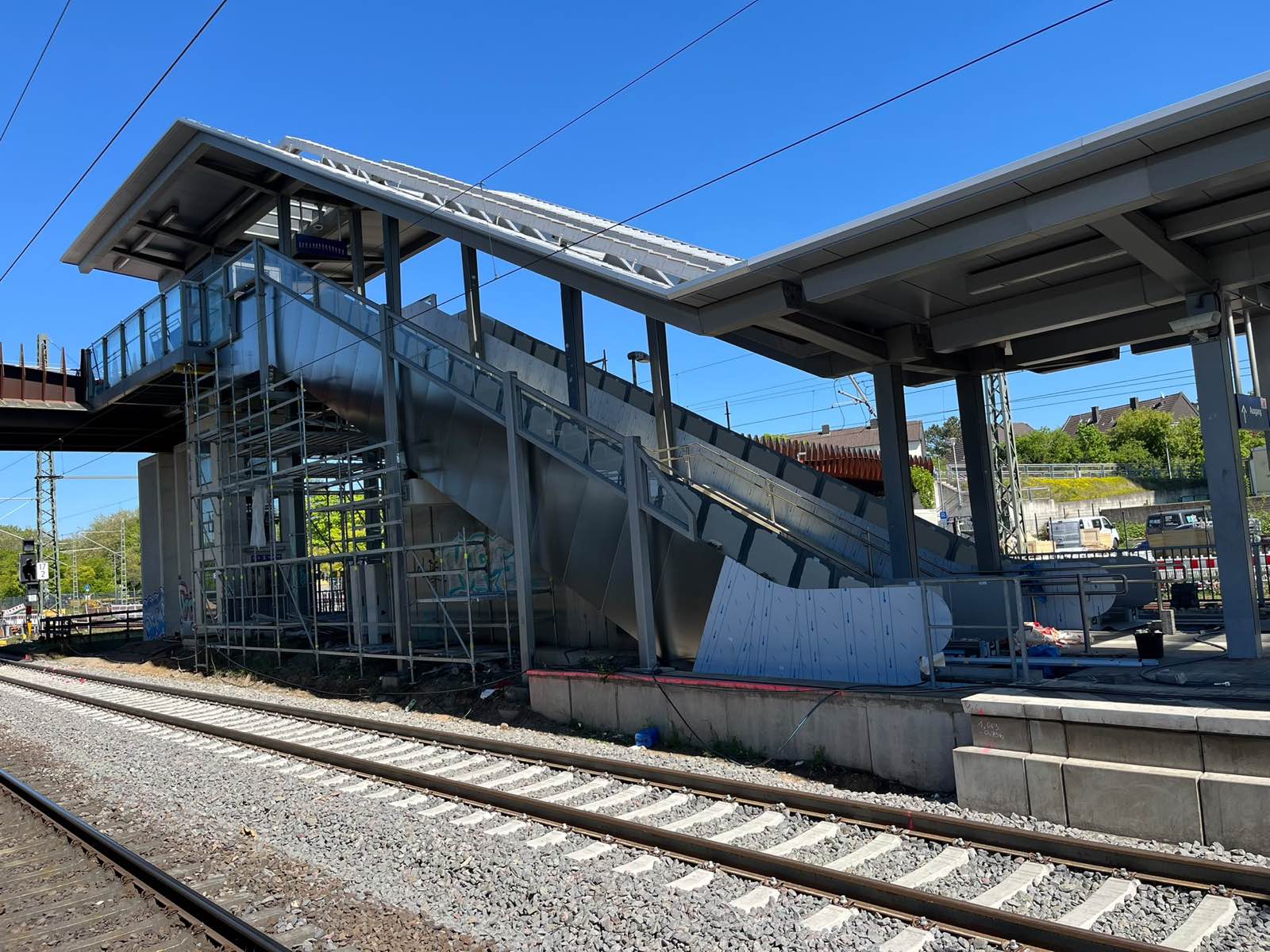Neu eingebrachte Fahrtreppe unter dem Bahnsteigdach eines Bahnhofs während der Bauphase