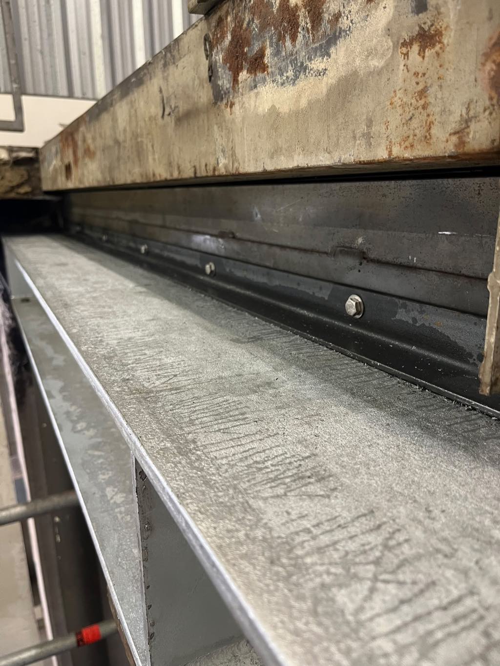 Detailaufnahme eines Stahlauflagers unter einer Betontreppe im Bestand